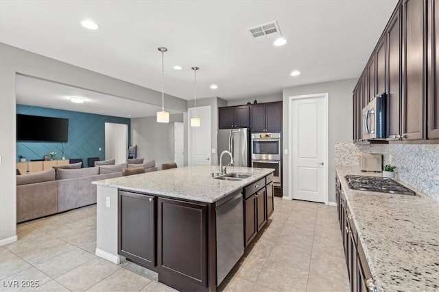 kitchen featuring stainless steel appliances, recessed lighting, a sink, and dark brown cabinetry