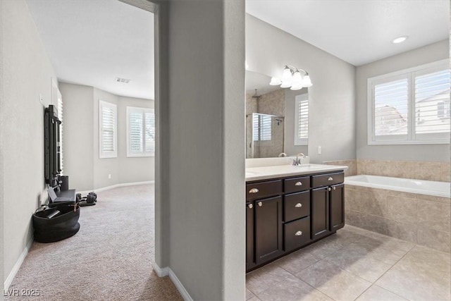 bathroom featuring a shower stall, vanity, tile patterned flooring, baseboards, and a bath