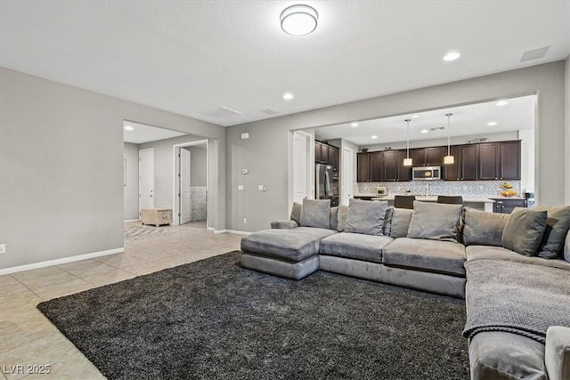 living area featuring recessed lighting, light tile patterned flooring, and baseboards