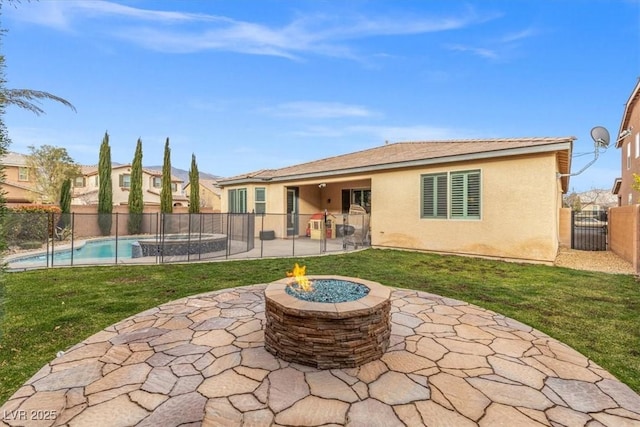 rear view of property with a patio, an outdoor fire pit, a fenced backyard, a lawn, and stucco siding