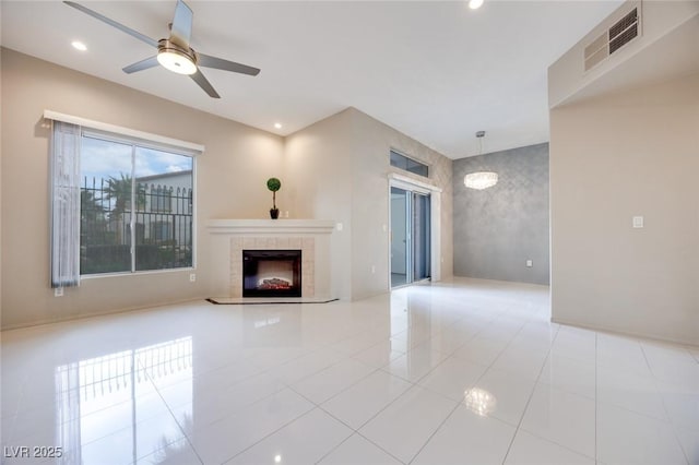 unfurnished living room with visible vents, a tile fireplace, tile patterned flooring, ceiling fan with notable chandelier, and recessed lighting