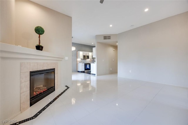 unfurnished living room with recessed lighting, visible vents, and a tiled fireplace