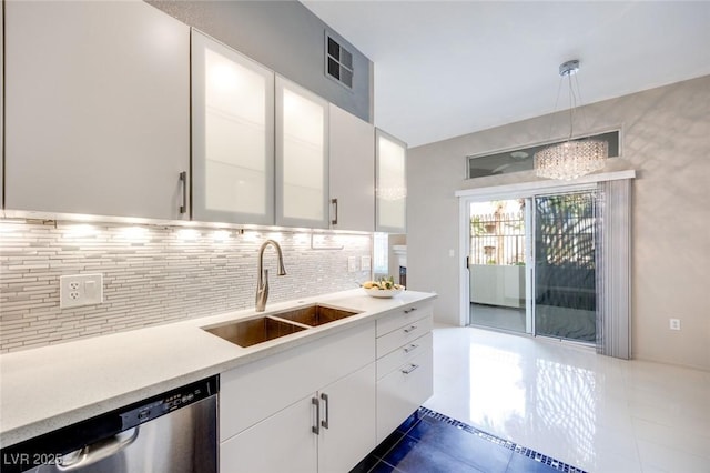 kitchen featuring dishwasher, light countertops, a sink, and white cabinetry