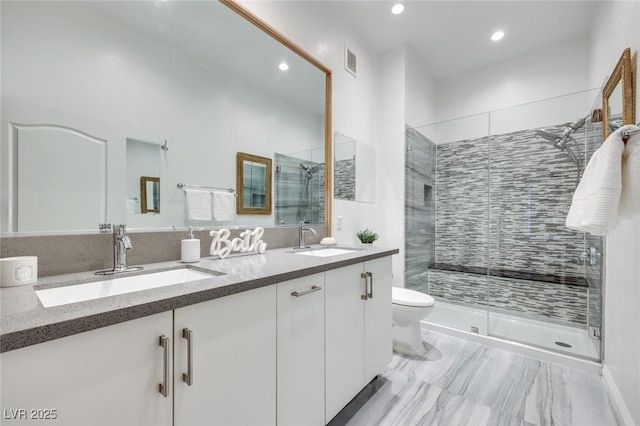 full bath with a stall shower, visible vents, a sink, and double vanity