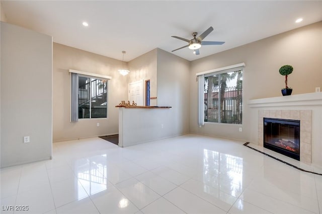 tiled living area with recessed lighting, ceiling fan, baseboards, and a tile fireplace