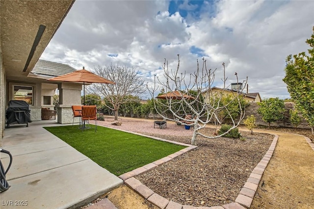 view of yard featuring a patio, a fire pit, and fence