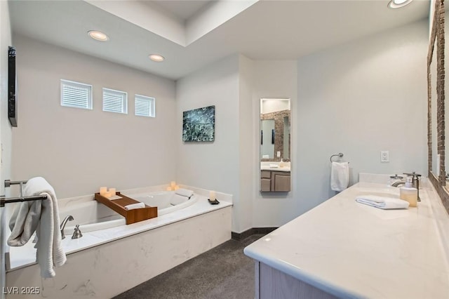 bathroom featuring a garden tub, recessed lighting, and vanity