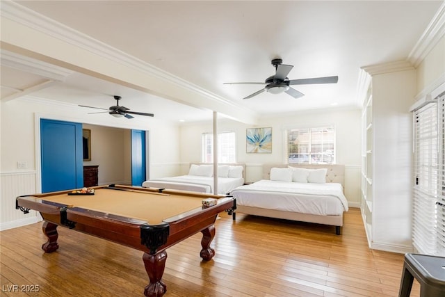 rec room with a wainscoted wall, a ceiling fan, light wood-style flooring, and crown molding