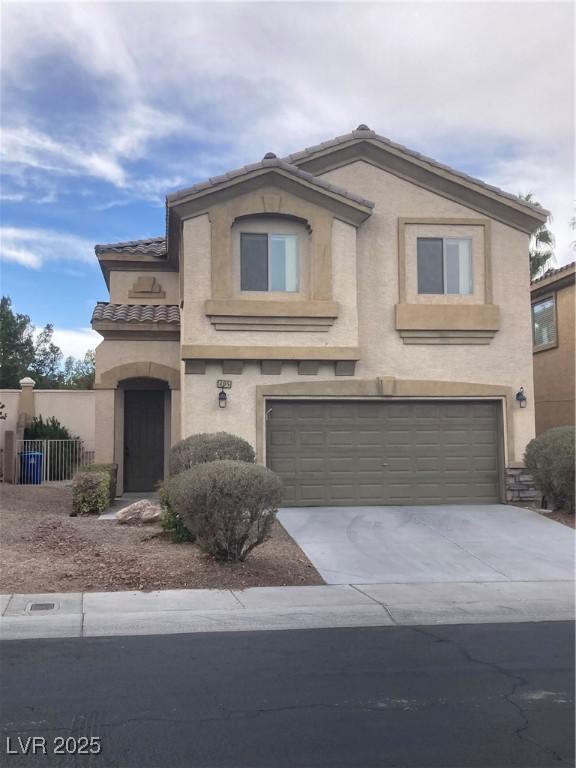 mediterranean / spanish home featuring fence, a tile roof, stucco siding, a garage, and driveway