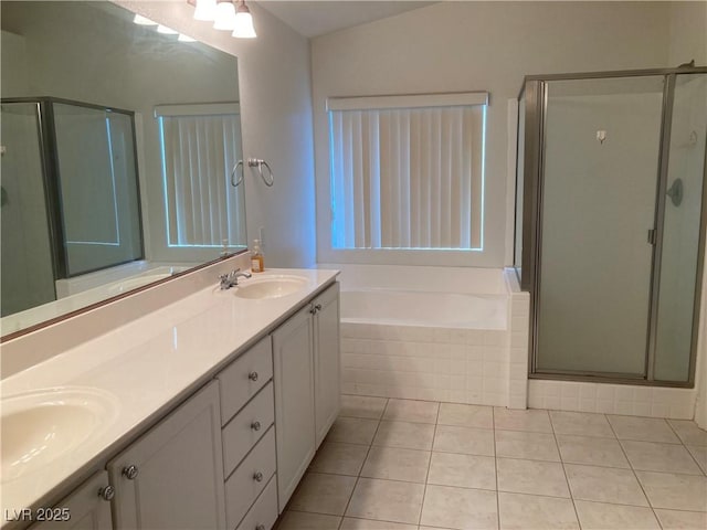 bathroom featuring a sink, a garden tub, a stall shower, and double vanity