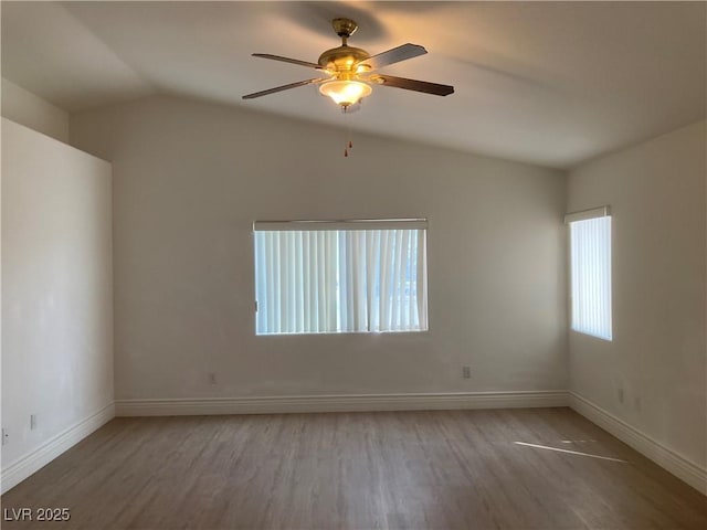 unfurnished room featuring lofted ceiling, light wood-style flooring, and baseboards