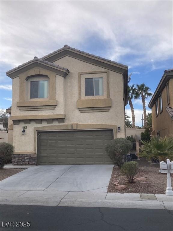 view of front of house with concrete driveway, an attached garage, and stucco siding