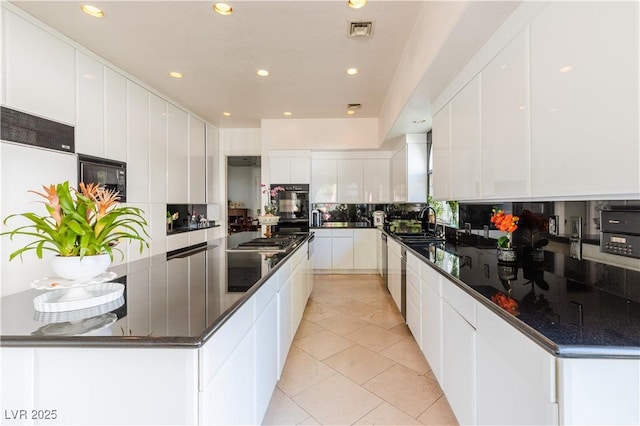 kitchen with modern cabinets, visible vents, backsplash, and stainless steel gas stovetop