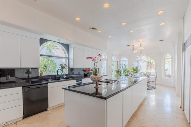 kitchen featuring visible vents, dishwasher, backsplash, white cabinetry, and a sink