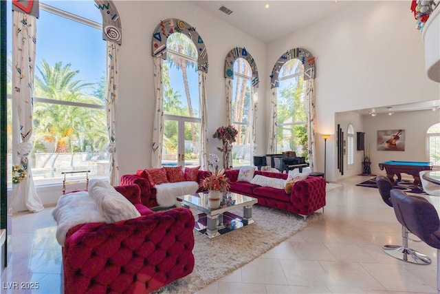 living room featuring a towering ceiling, tile patterned flooring, visible vents, and pool table