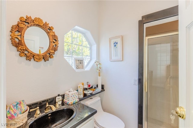 bathroom with tiled shower, vanity, and toilet