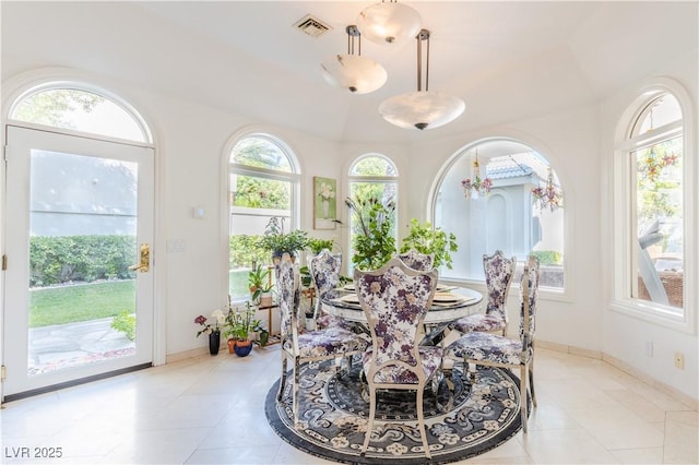 dining space with light tile patterned floors, visible vents, and baseboards