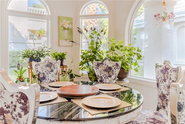 sunroom / solarium featuring a notable chandelier