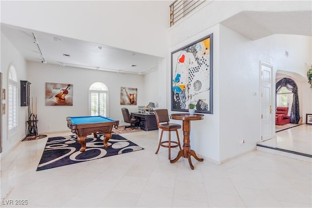 game room with arched walkways, pool table, a high ceiling, baseboards, and track lighting