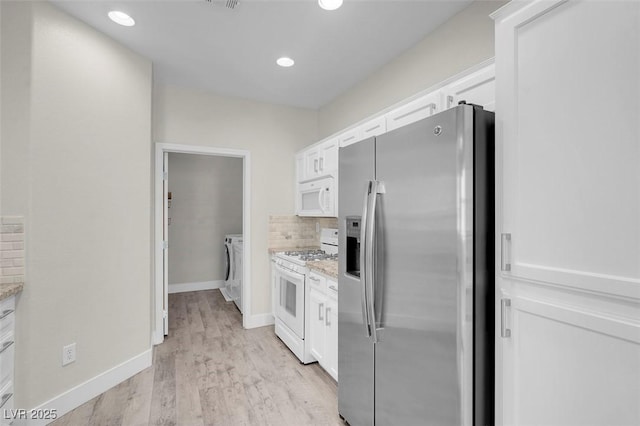 kitchen featuring decorative backsplash, light wood-style floors, white appliances, white cabinetry, and separate washer and dryer