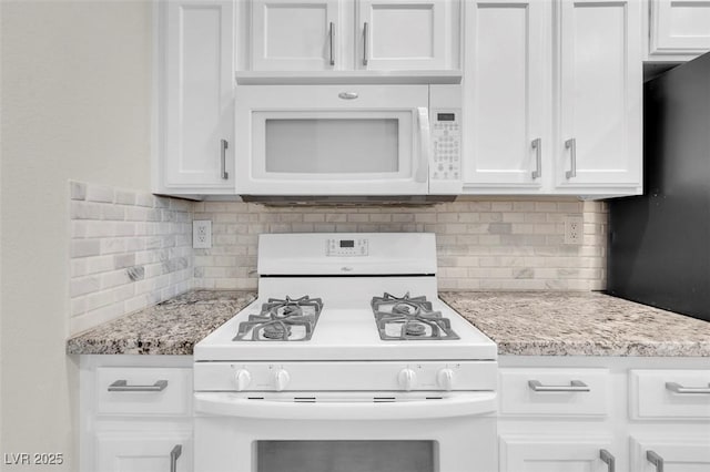 kitchen featuring white appliances, backsplash, light stone countertops, and white cabinetry