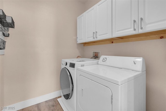 laundry area featuring cabinet space, light wood-style flooring, baseboards, and separate washer and dryer