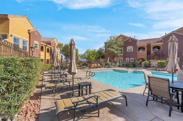 pool with a patio area and fence