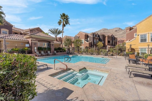 pool featuring a patio area, fence, and a hot tub