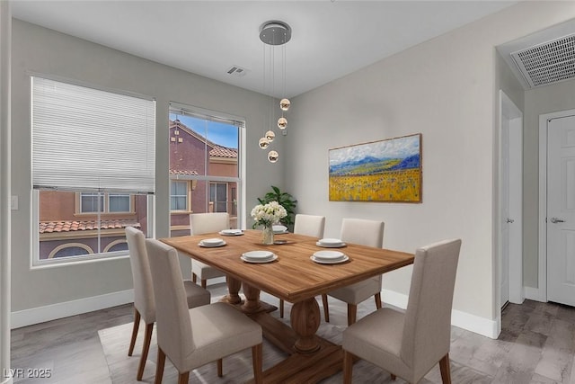 dining area with visible vents, baseboards, and wood finished floors