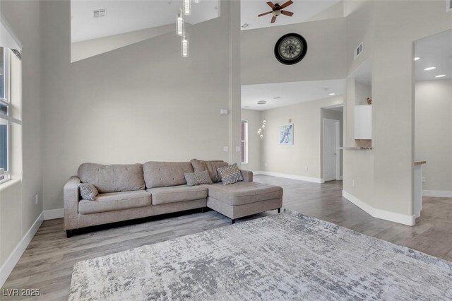 living area with wood finished floors, visible vents, and baseboards