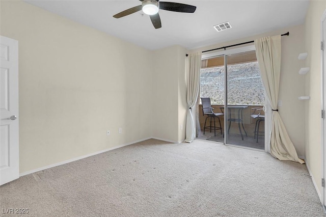 carpeted spare room featuring visible vents, baseboards, and ceiling fan