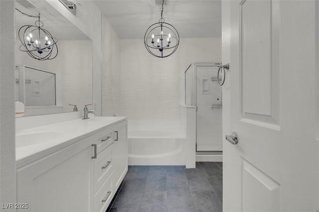 bathroom with a sink, an inviting chandelier, a shower stall, and double vanity