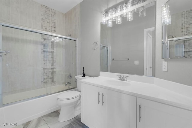 bathroom featuring vanity, toilet, marble finish floor, and enclosed tub / shower combo