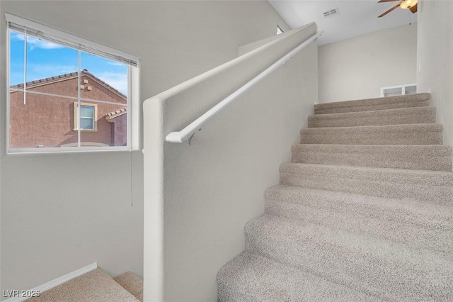 stairway featuring visible vents, baseboards, and ceiling fan