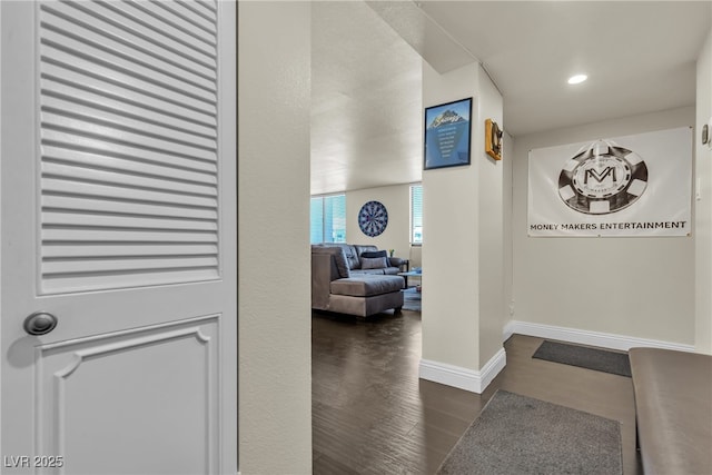 hallway featuring dark wood-style flooring, recessed lighting, and baseboards