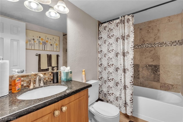 bathroom featuring a textured wall, shower / bath combo, vanity, and toilet