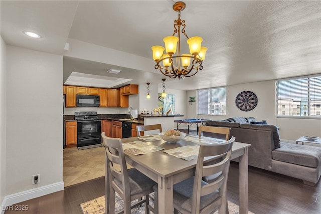 dining room featuring visible vents, an inviting chandelier, a textured ceiling, wood finished floors, and baseboards