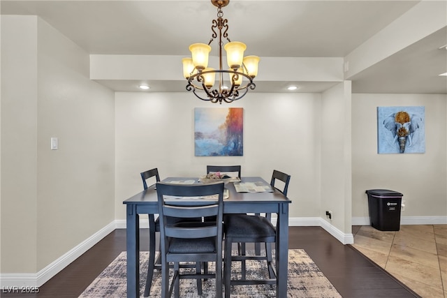 dining room featuring a chandelier, wood finished floors, and baseboards