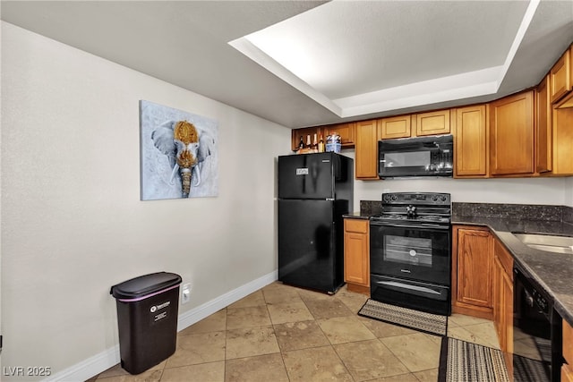 kitchen with light tile patterned flooring, baseboards, black appliances, brown cabinetry, and dark stone countertops