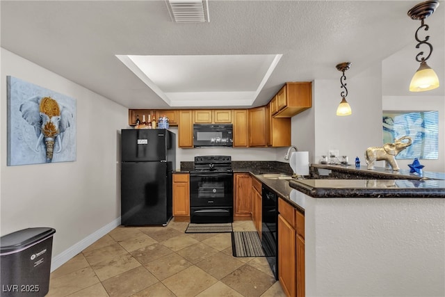 kitchen featuring a sink, baseboards, black appliances, dark stone countertops, and decorative light fixtures