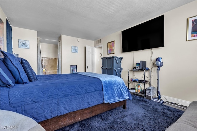 bedroom with a textured ceiling and baseboards