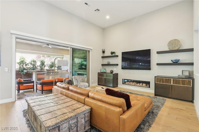 living room with recessed lighting, a glass covered fireplace, ceiling fan, wood finished floors, and baseboards