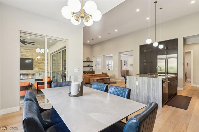 dining area with baseboards, light wood-type flooring, a notable chandelier, and recessed lighting