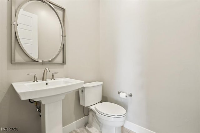 bathroom with baseboards and toilet