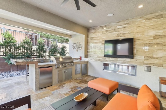 view of patio with exterior kitchen, a ceiling fan, a grill, and fence