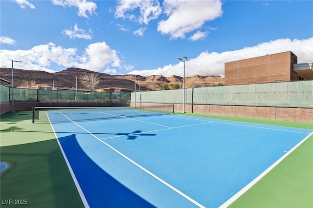 view of sport court with fence and a mountain view