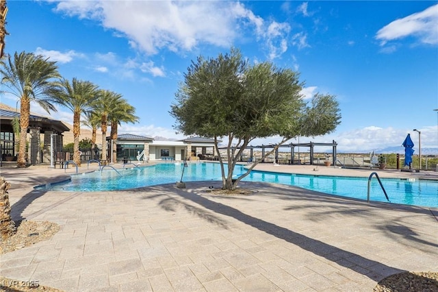 community pool featuring fence and a patio