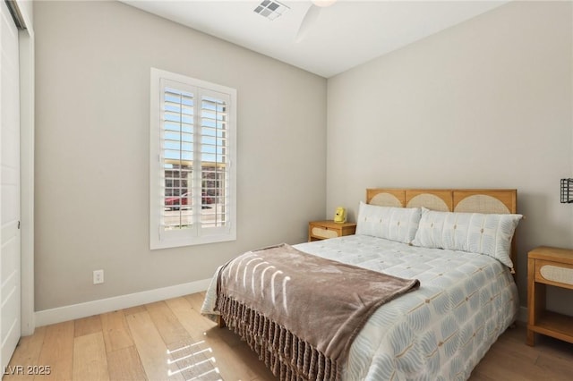 bedroom with visible vents, baseboards, and wood finished floors