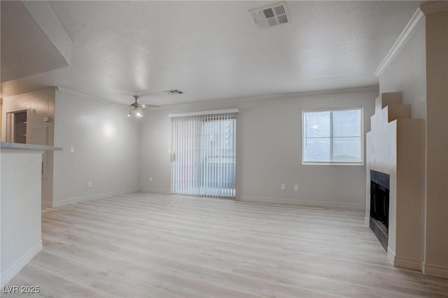 unfurnished living room featuring a ceiling fan, light wood-style floors, visible vents, and a fireplace