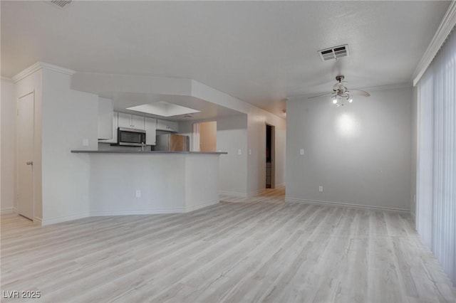 kitchen with stainless steel appliances, visible vents, light wood-style flooring, open floor plan, and ceiling fan